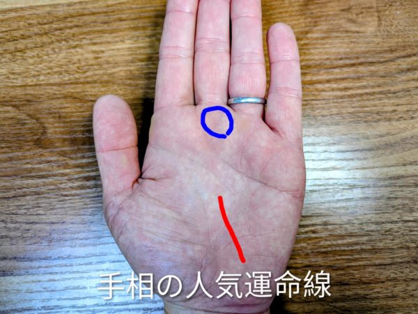 平塚の占いを求めている女性向け手相解説画像。月丘から伸びる「人気運命線」(赤線)と土星丘(中指の付け根を目指す)(青丸)を示し、他人軸の生き方の期限切れや転機を伝える。「手相の人気運命線」の文字入り。