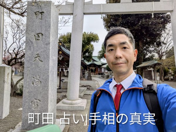 町田天満宮の石碑前で。「町田 占い」で50代女性の才能を読み解く手相鑑定士の後藤。