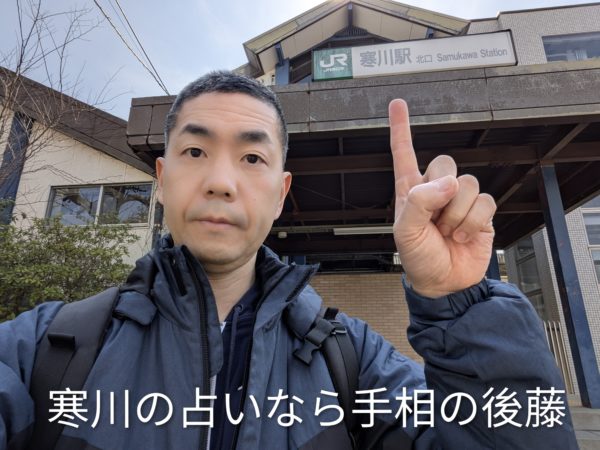 JR寒川駅北口の看板下で、寒川の占いなら手相の後藤とアピールする様子